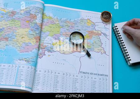 Carte de la Turquie sur un livre, prenant des notes sur les préparatifs d'un voyage en voiture. Une loupe et une boussole à gauche de la page. Banque D'Images