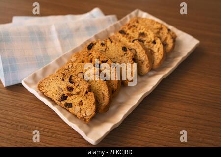 Motif de biscuits aux amandes fraîchement cuits sur fond de tissu à carreaux bleu et blanc. Banque D'Images