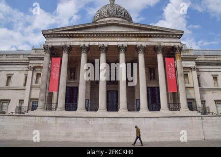 Londres, Royaume-Uni. 30 avril 2021. Un homme passe devant la National Gallery de Trafalgar Square, qui a été fermée pendant une grande partie du temps depuis le début de la pandémie du coronavirus. Les musées doivent rouvrir le 17 mai. Banque D'Images