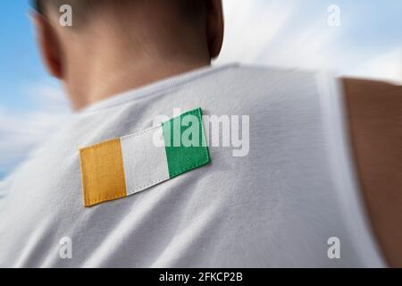 Le drapeau national de la Côte d'Ivoire sur le dos de l'athlète Banque D'Images