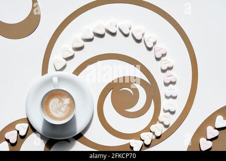 Tasse à café, cercles de séquence Fibonacci en papier brun et coeurs de sucre. Latte Art au motif floral, une perfection savoureuse. Concept Golden ratio Banque D'Images