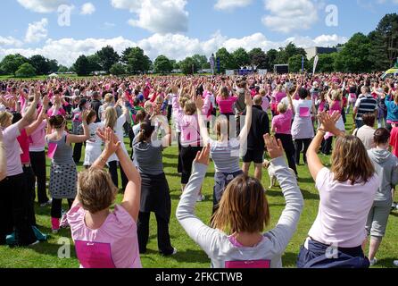 Les femmes se réchauffent avant le début d'une course de recherche sur le cancer pour la vie à Moat Park, Maidstone, Kent, Royaume-Uni. Les femmes, les femmes qui s'exécutent pour la charité Banque D'Images