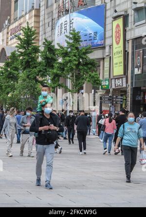 Pékin, Chine. 28 avril 2021. Les personnes portant un masque facial marchent le long de la rue Wangfujing à Pékin. La population de la Chine continue de croître depuis 2020, a déclaré jeudi le Bureau national de statistique (NBS). Les données spécifiques seront publiées dans le 7e bulletin national de recensement de la population, a déclaré le NBS dans une brève déclaration sur son site Web. Le 7e recensement national de la population a été lancé en novembre de l'année dernière. Crédit : SOPA Images Limited/Alamy Live News Banque D'Images