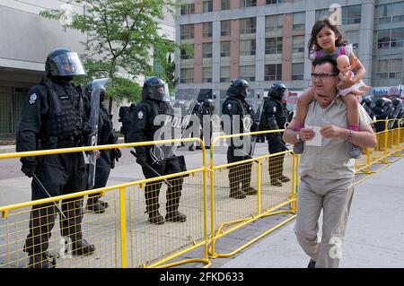 Toronto (Ontario), Canada - 25 juin 2010 : le papa et la jeune fille à pied passent les politiques anti-émeute Banque D'Images