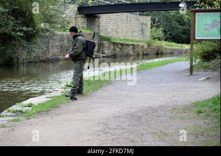 Homme pêchant dans le canal de Macclesfield à Bollington Banque D'Images