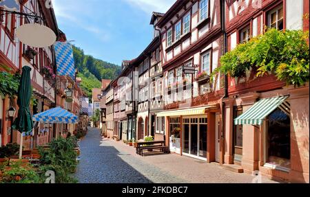 Beau restaurant, rue bordée de bâtiments traditionnels à colombages dans la ville de Miltenberg, Bavière, Allemagne Banque D'Images