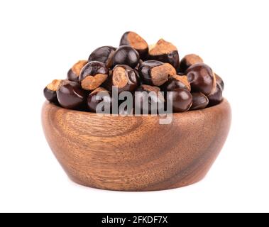 Graines de guarana dans un bol en bois, isolées sur fond blanc. Supplément alimentaire guarana, source de caféine pour boissons énergétiques. Banque D'Images