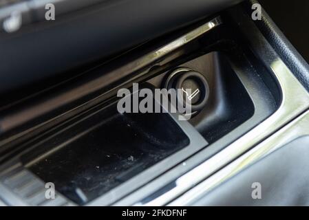 Allume-cigare électronique sur la console du tableau de bord de voiture avec cendrier pour fumer pendant la conduite. Banque D'Images