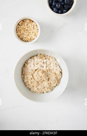 Bol de porridge, bol de bleuets et un bol d'avoine sur comptoir en marbre blanc Banque D'Images