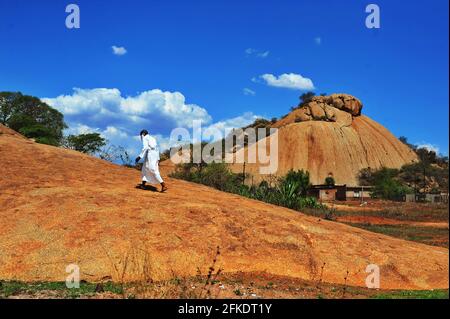 Les adorateurs africains qui mondent une colline rocheuse prient par temps clair avec le ciel bleu à Limpopo, en Afrique du Sud Banque D'Images