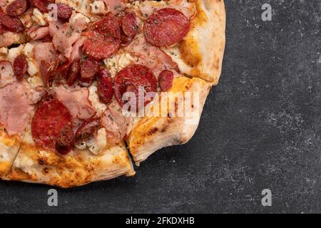 Quatre pizzas à base de viande sur fond de béton foncé Banque D'Images