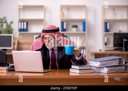 Un employé arabe âgé boit du café pendant la pause Banque D'Images
