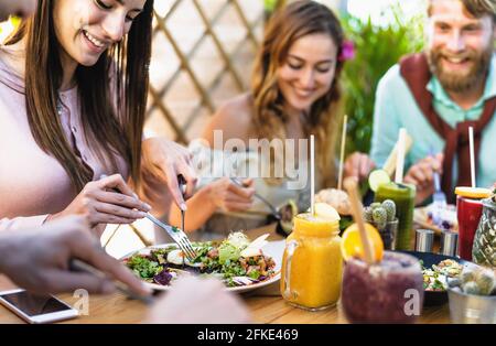 Des amis heureux se déjeunant avec des aliments sains dans le brunch du café du bar - les jeunes ayant plaisir à manger et à boire frais smoothies au restaurant Banque D'Images