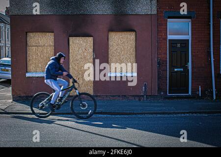 Homme en vélo passant a embarqué des fenêtres et des portes dans les rues les plus privées, qui sont autour du centre-ville de Hartlepool, comté de Durham, Royaume-Uni Banque D'Images