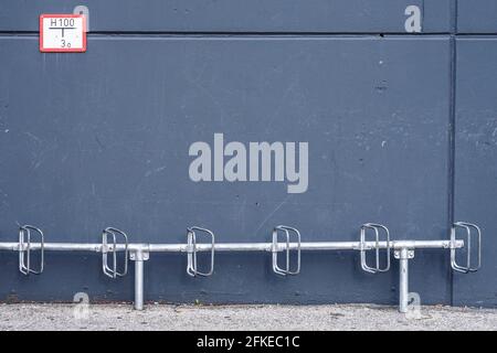 Porte-vélos devant un mur gris. Banque D'Images