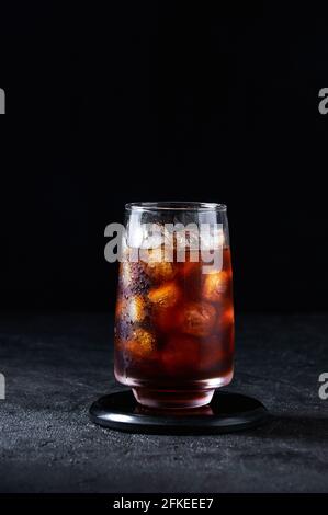 Coca glacé ou café froid dans le grand verre sur fond sombre. Boisson D'Été Rafraîchissante Concept. Banque D'Images