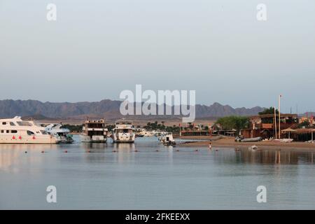 Baie et navires sur l'eau. Station de bateau sur la rive. Basses montagnes au loin. Resort sur la côte de la mer Rouge, Safaga, Egypte Banque D'Images