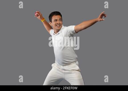 Joueur de cricket, joueur de terrain qui lance une balle Banque D'Images