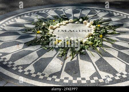 Les fleurs entourent la mosaïque vivante du mémorial « imagine » qui est un hommage à John Lennon des Beatles, Central Park, New York City, États-Unis Banque D'Images