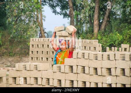 Photo d'un four en brique dans le quartier isolé de Hooghly. Les travailleurs adultes travaillent dur pour arranger les briques brutes dans le four à cuire. Banque D'Images