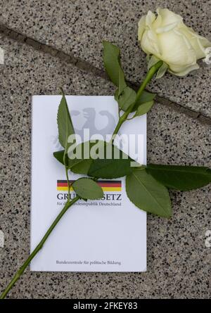 Erfurt, Allemagne. 1er mai 2021. Une rose blanche sur un livre de droit de base se trouve devant l'entrée du centre de justice avec le tribunal de district. Des roses blanches ont été déposées devant les tribunaux dans plusieurs villes de Thuringe en réaction au verdict masque controversé d'un juge du district de Weimar. Credit: Michael Reichel/dpa-Zentralbild/dpa/Alay Live News Banque D'Images