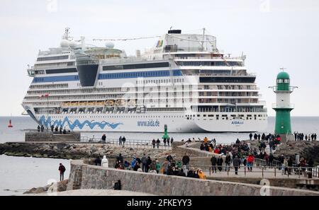 01 mai 2021, Mecklembourg-Poméranie occidentale, Warnemünde : les spectateurs regardent le départ de l''AIDAsol', qui quitte la station balnéaire de la mer Baltique après un séjour d'une semaine au terminal de croisière. Le navire a visité Warnemünde sans passagers en raison de corona et a testé le nouveau système d'alimentation terrestre, qui sera en mesure de fournir de l'électricité aux navires de croisière à l'avenir. Photo: Bernd Wüstneck/dpa-Zentralbild/dpa Banque D'Images