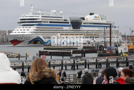 01 mai 2021, Mecklembourg-Poméranie occidentale, Warnemünde : les spectateurs regardent le départ de l''AIDAsol', qui quitte la station balnéaire de la mer Baltique après un séjour d'une semaine au terminal de croisière. Le navire a visité Warnemünde sans passagers en raison de corona et a testé le nouveau système d'alimentation terrestre, qui sera en mesure de fournir de l'électricité aux navires de croisière à l'avenir. Photo: Bernd Wüstneck/dpa-Zentralbild/dpa Banque D'Images