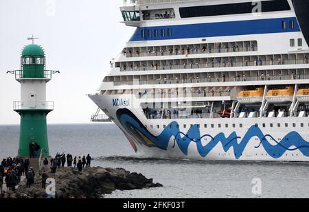 01 mai 2021, Mecklembourg-Poméranie occidentale, Warnemünde : l'équipage se tient à bord et se déchaîne alors que l'« AIDAsol » quitte la station balnéaire de la mer Baltique après un séjour d'une semaine au terminal de croisière. Le navire a visité Warnemünde sans passagers pour des raisons de corona et a testé le nouveau système d'alimentation terrestre, qui sera en mesure de fournir de l'électricité aux navires de croisière à l'avenir. Photo: Bernd Wüstneck/dpa-Zentralbild/dpa Banque D'Images