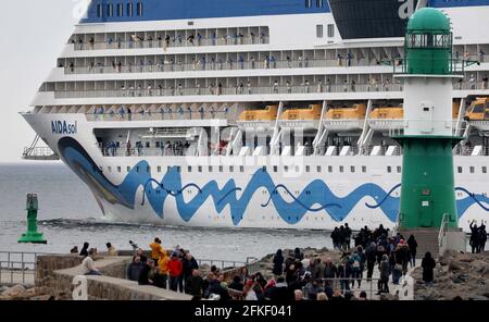 01 mai 2021, Mecklembourg-Poméranie occidentale, Warnemünde : l'équipage se tient à bord et se déchaîne alors que l'« AIDAsol » quitte la station balnéaire de la mer Baltique après un séjour d'une semaine au terminal de croisière. Le navire a visité Warnemünde sans passagers pour des raisons de corona et a testé le nouveau système d'alimentation terrestre, qui sera en mesure de fournir de l'électricité aux navires de croisière à l'avenir. Photo: Bernd Wüstneck/dpa-Zentralbild/dpa Banque D'Images