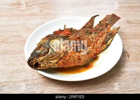 faire frire la vinaigrette au poisson frit à la mangue, épicée et sucrée plaque Banque D'Images