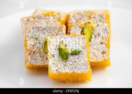 Célèbre Indien Mithai Moong Dal Burfi Barfee ou Meetha Mung Daal Barfi fait de farine de Gram jaune à Desi ghee mélangé avec Mawa Pistachio et Koya. Isol Banque D'Images