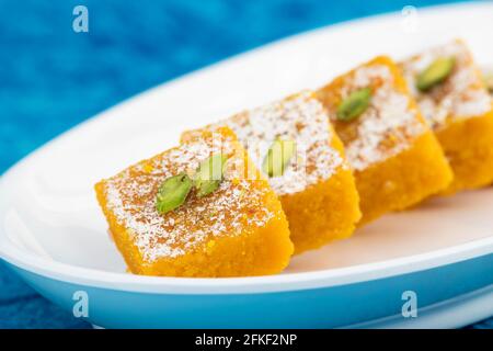 Célèbre Indien Mithai Moong Dal Burfi ou Meetha Mung Daal Barfi Barfee fait de farine de Gram jaune à Desi ghee Mélangé avec Mawa Pistachio et Koya dans tr Banque D'Images