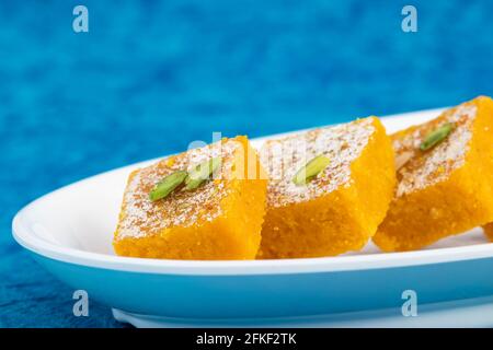 Traditionnel indien Mithai Moong Dal Burfi ou Meetha Mung Daal Barfi Barfee cuisiné à Desi ghee dans un plateau blanc Angle bas vu du côté O. Banque D'Images