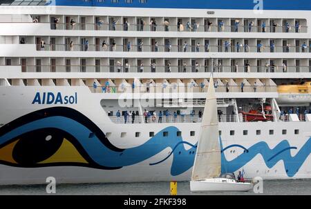 01 mai 2021, Mecklembourg-Poméranie occidentale, Warnemünde : l'équipage se tient à bord et se déchaîne alors que l'« AIDAsol » quitte la station balnéaire de la mer Baltique après un séjour d'une semaine au terminal de croisière. Le navire a visité Warnemünde sans passagers pour des raisons de corona et a testé le nouveau système d'alimentation terrestre, qui sera en mesure de fournir de l'électricité aux navires de croisière à l'avenir. Photo: Bernd Wüstneck/dpa-Zentralbild/ZB Banque D'Images