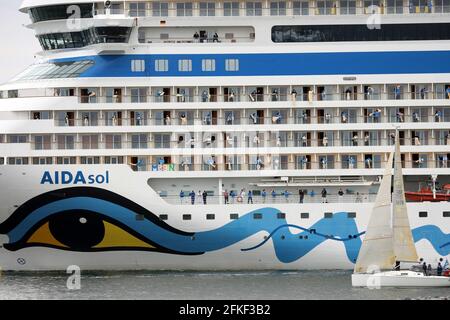 01 mai 2021, Mecklembourg-Poméranie occidentale, Warnemünde : l'équipage se tient à bord et se déchaîne alors que l'« AIDAsol » quitte la station balnéaire de la mer Baltique après un séjour d'une semaine au terminal de croisière. Le navire a visité Warnemünde sans passagers pour des raisons de corona et a testé le nouveau système d'alimentation terrestre, qui sera en mesure de fournir de l'électricité aux navires de croisière à l'avenir. Photo: Bernd Wüstneck/dpa-Zentralbild/ZB Banque D'Images