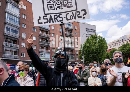 Un denier COVID-19 tient un écriteau sur la Plaza Conde de Casal pendant le rallye.dans le cadre de la Journée internationale du travail du 1er mai, le parti d'extrême-droite espagnol VOX lance le syndicat 'Solidaridad'. Avec des discours anti-communistes, anti-écologiques, anti-illégaux, anti-féministes et ultra-nationalistes, Santiago Abascal, président de VOX, Rocio Monasterio, candidat aux élections de la Communauté de Madrid, et Rodrigo Alonso, secrétaire général du syndicat Solidaridad ont participé à la réunion sur la Plaza de Comte Casal. La loi a lieu quelques jours avant les élections Banque D'Images