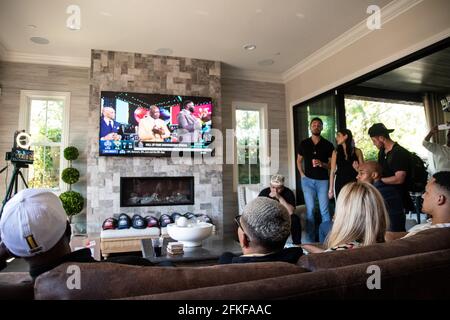 Lake Forest, États-Unis. 30 avril 2021. Amon-Ra St. Brown (deuxième à partir de la gauche) est assis sur un canapé à côté de sa mère Miriam Brown et de son père John Brown (à gauche) pendant le projet de la NFL, en regardant la télévision. Le confrère Equanimeous St. Brown joue déjà dans la NFL et est sous contrat avec les Green Bay Packers. Dans le projet, les 32 équipes de la NFL se mettent à sélectionner tour de rôle de jeunes joueurs. Les pros potentiels n'ont pas leur mot à dire dans quelle équipe ils commencent leur carrière à la Ligue nationale de football. Credit: Maximilian Haupt/dpa/Alay Live News Banque D'Images