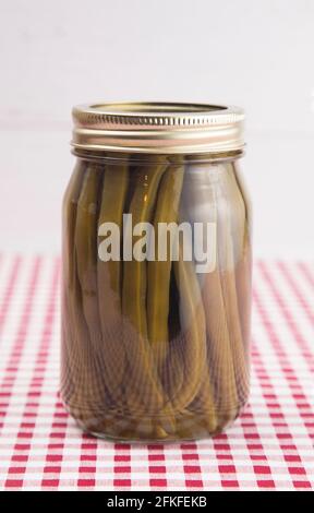 Haricots verts sur un chiffon de table Vichy rouge dans un Pot de conserve Home Banque D'Images