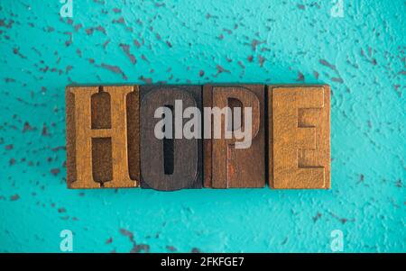 L'espoir est orthographié dans des lettres de blocage de type en bois sur un Fond turquoise Banque D'Images