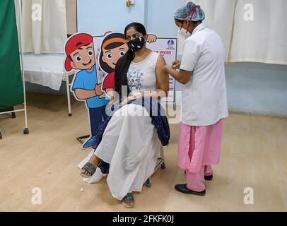 Mumbai, Inde. 1er mai 2021. Une femme portant un masque facial reçoit une dose du vaccin Covishield au centre de vaccination de l'hôpital Rajawadi à Mumbai. L'entraînement de vaccination pour le groupe d'âge de 18-44 ans a commencé le 1er mai 2021. Seules les personnes admissibles au vaccin ont reçu une confirmation de leur inscription au téléphone. Crédit : SOPA Images Limited/Alamy Live News Banque D'Images