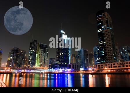 Une pleine lune brille au-dessus de la marina de Dubaï, aux Émirats arabes Unis Banque D'Images