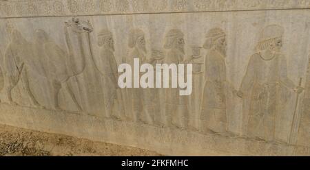 Gros plan de soulagement de personnes portant des cadeaux à la Ruines antiques de la ville de Persepolis en Iran Banque D'Images