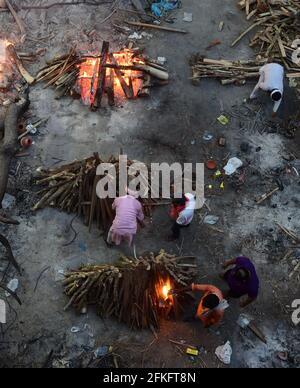 New Delhi, Inde. 1er mai 2021. Les travailleurs et les membres de la famille apportent un corps de crémation près de plusieurs pyres funéraires des victimes de COVID-19 brûlent sur un terrain qui a été converti en crématorium pour la crémation de masse à New Delhi, en Inde, le samedi 1er mai 2021. Photo par Abhishek/UPI crédit: UPI/Alay Live News Banque D'Images