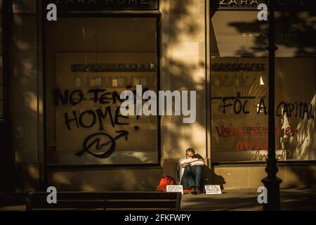 Barcelone, Espagne. 1er mai 2021. Un homme sans domicile se trouve devant un magasin ZARA, après que des militants aient peint « nous n'avons pas de maison » sur la fenêtre lors d'une manifestation contre une grande variété de groupes de gauche marquant le 1er mai à Barcelone Credit: Matthias Oesterle/Alay Live News Banque D'Images