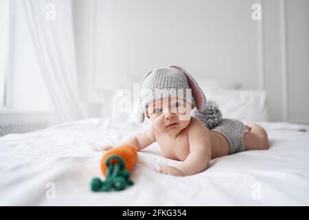 bébé heureux enfant en costume un lapin sur un arrière-plan blanc Banque D'Images