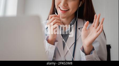 Femme asiatique médecin est en ligne de visite avec un patient sur L'application Internet et l'écoute des symptômes et explique comment traiter le d initial Banque D'Images