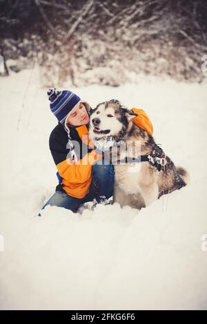 chien d'animal et propriétaire un homme assis en hiver forêt Banque D'Images