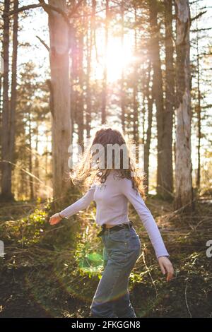 Jeune fille brune marchant dans la forêt Banque D'Images