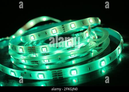 Gros plan d'une bande de silicone à LED avec lumières vertes sur fond noir Banque D'Images