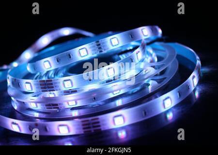 Gros plan d'une bande de silicone à LED avec lumières bleues sur fond noir Banque D'Images